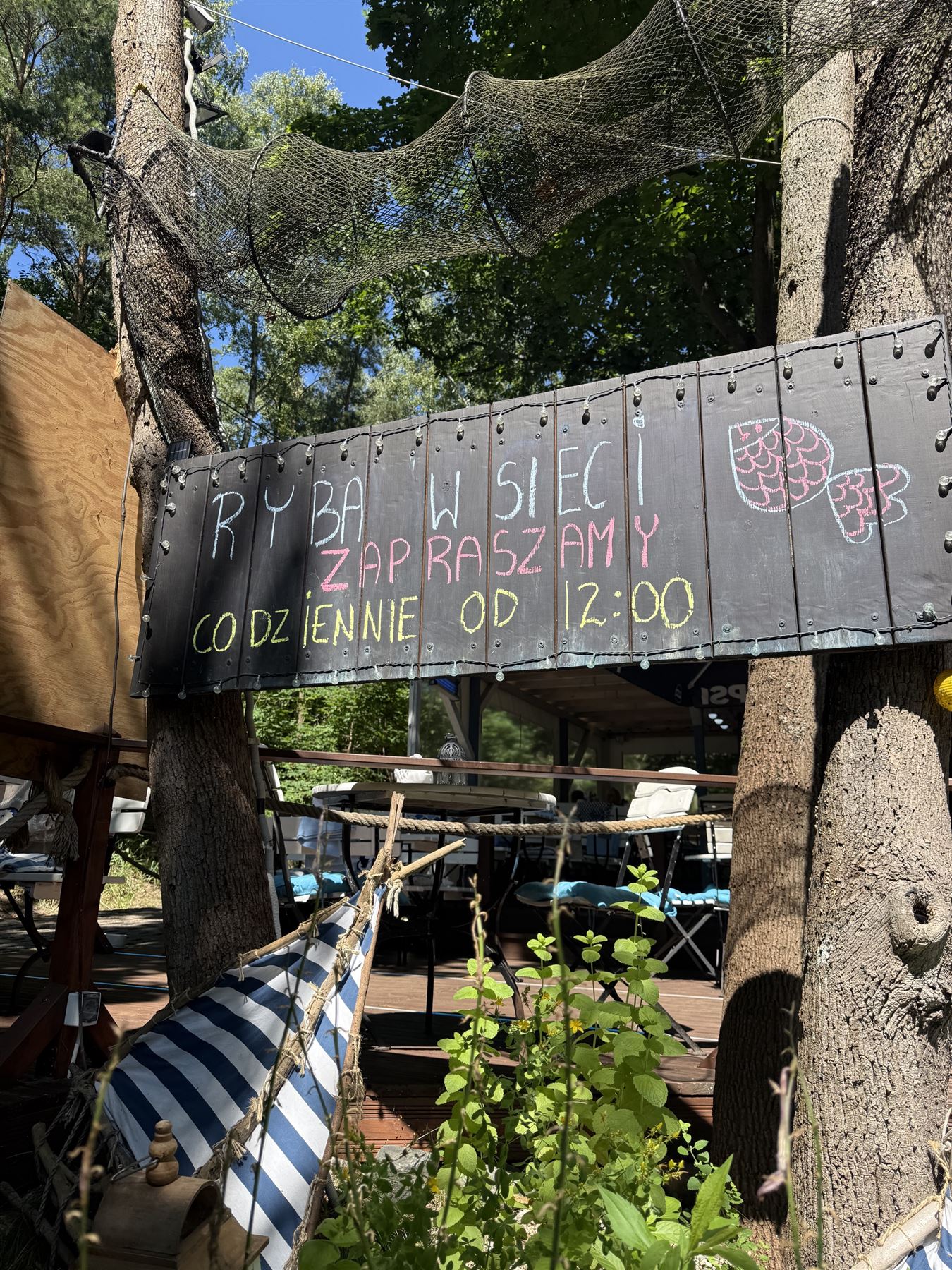 Rybacka sieć i tablica powitalna na tarasie restauracji Ryba w Sieci